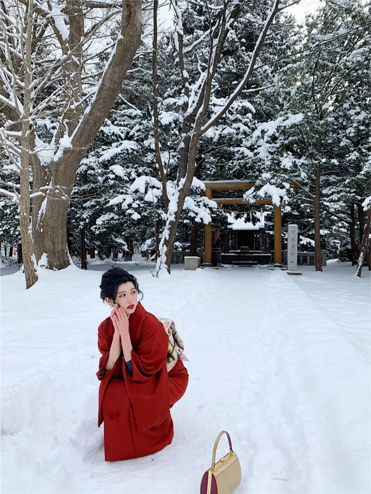 woman in snow with a red silk kimono