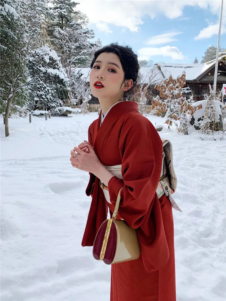 japanese woman in snow wearing a red silk kimono