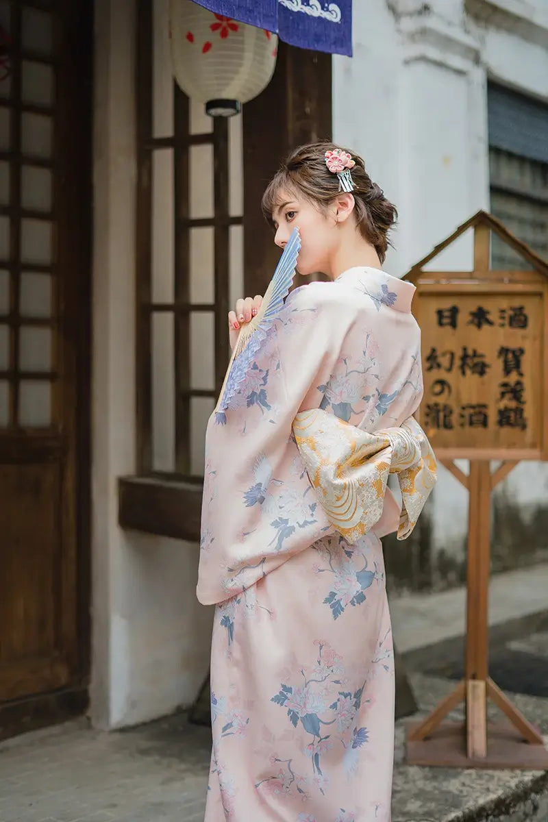 woman with a japanese fan wearing a pink kimono robe