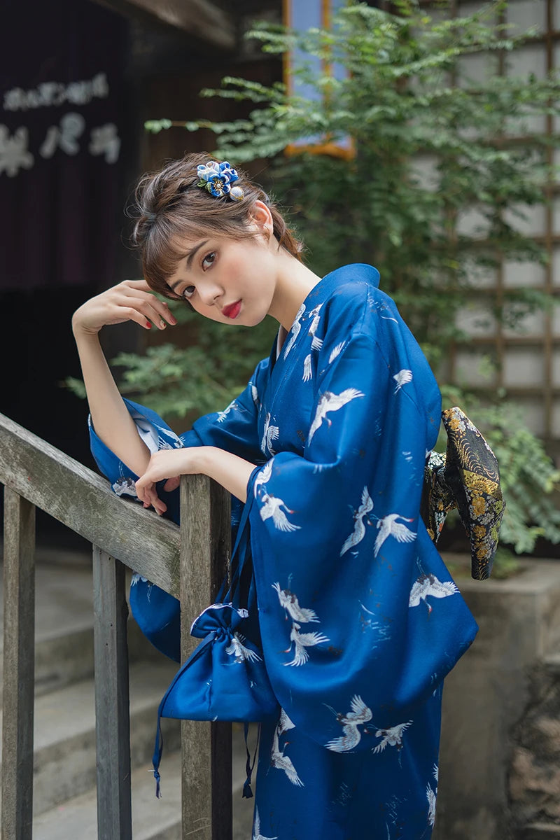 japanese woman wearing blue kimono with cranes