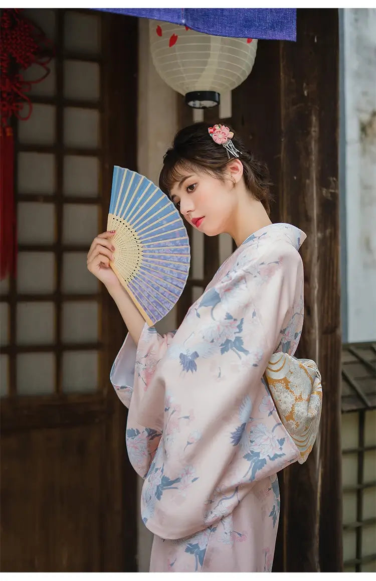 woman with a fan wearing a pink kimono robe