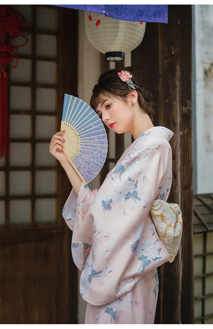 woman with a fan wearing a pink kimono robe