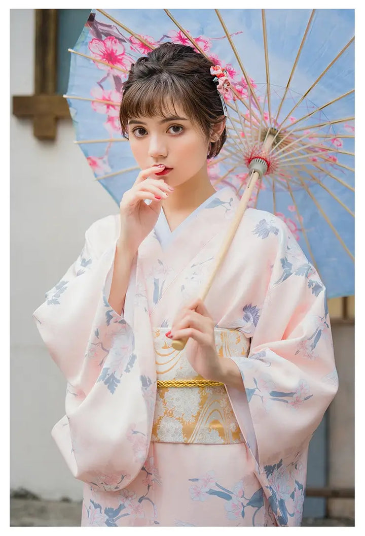 woman with an umbrella wearing a pink kimono robe