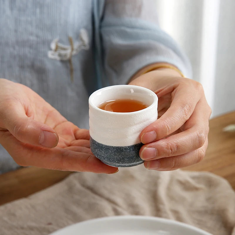 woman holding a cup of a authentic japanese sake set with warmer