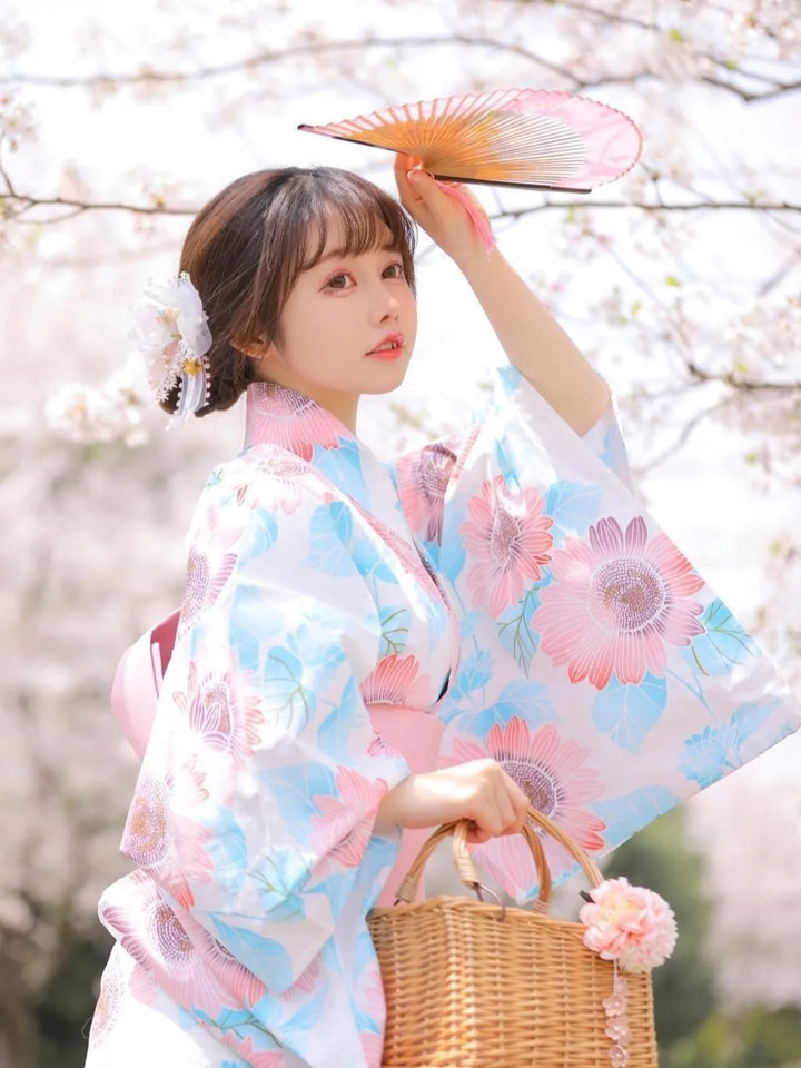 woman with a japanese fan wearing a pink and blue kimono