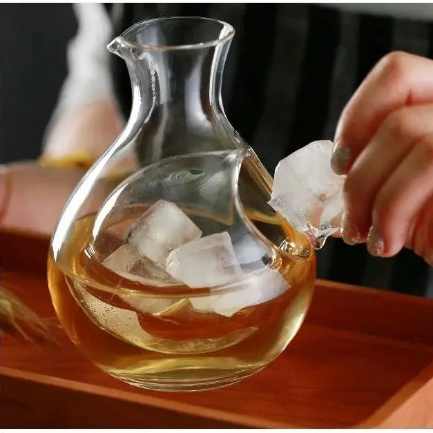 putting ice in a cold sake glass set on a table