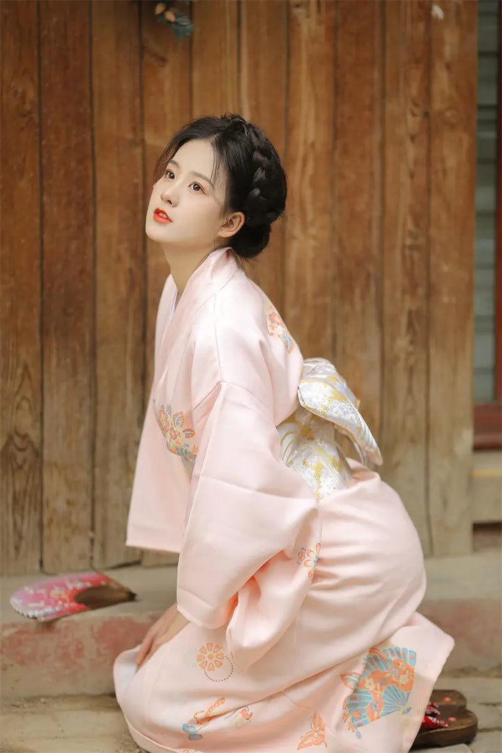 sitted woman wearing light pink kimono