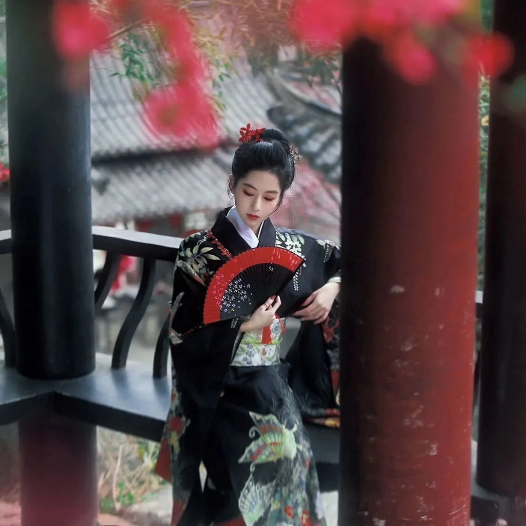 woman with a japanese fan wearing a black kimono robe