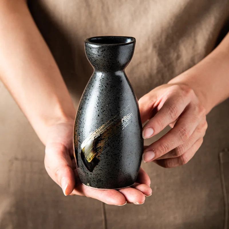 man holding a bottle from a japanese sake drink set