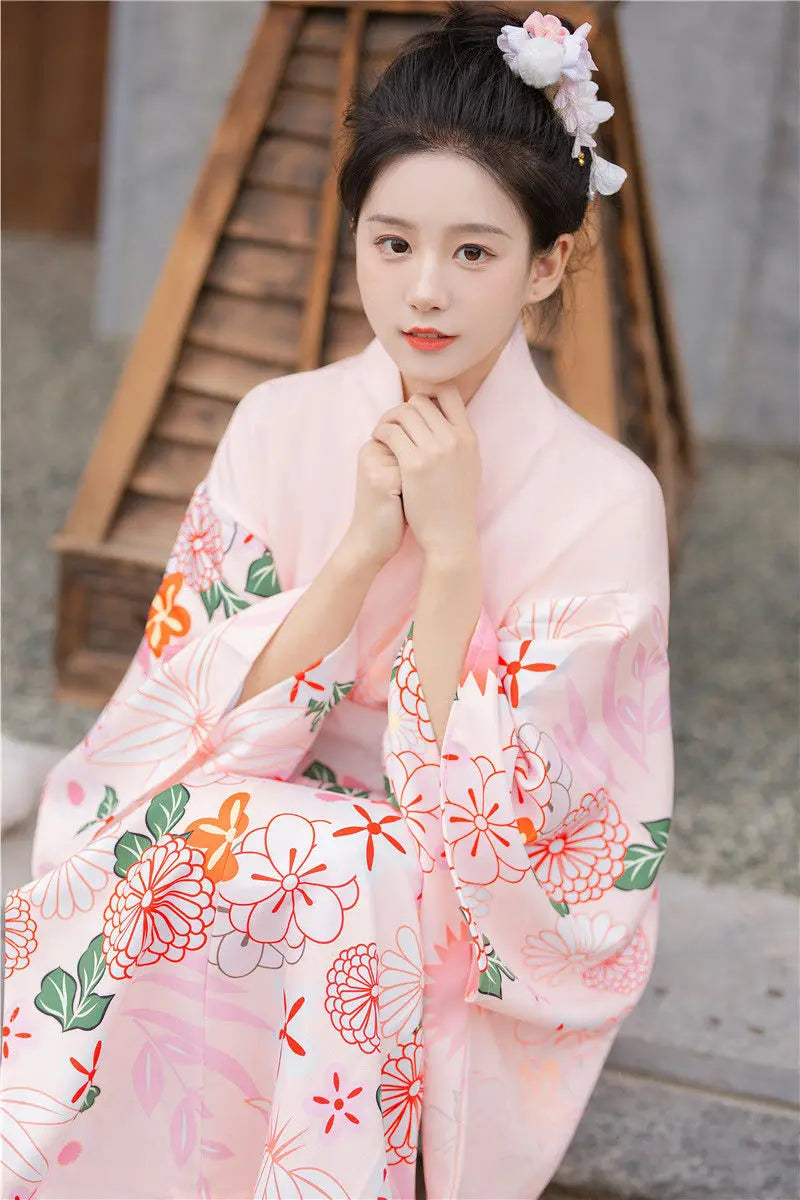 happy sitted woman with a pink floral kimono