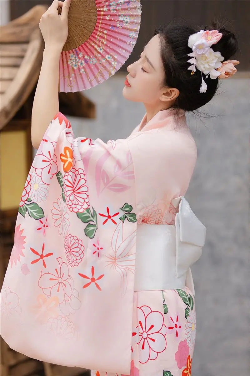 woman with a fan wearing pink floral kimono