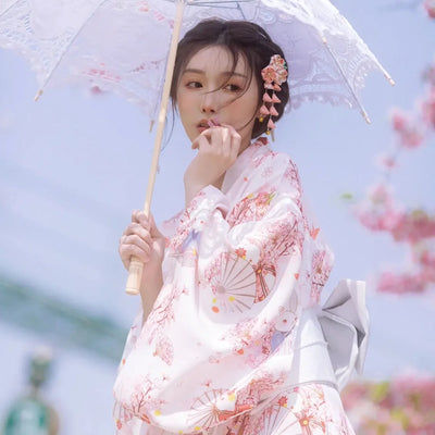 japanese woman in umbrella wearing a pink and white kimono