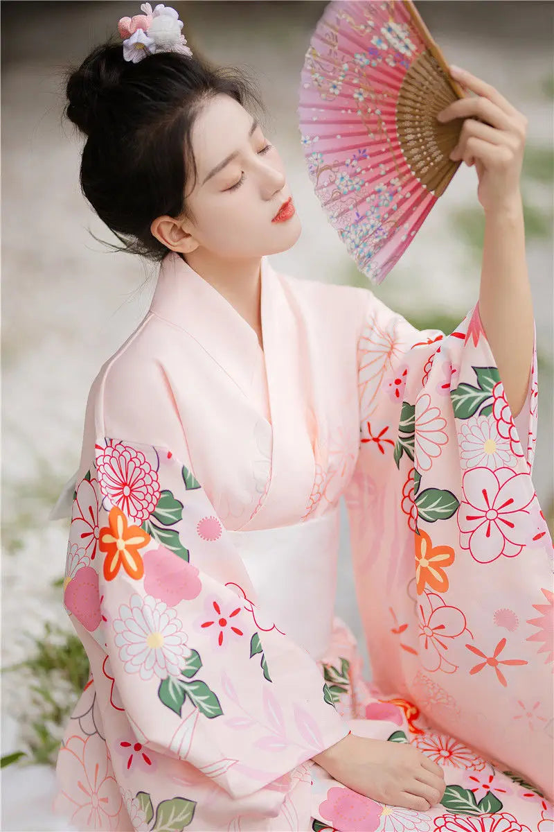 woman with a japanese fan wearing a japanese pink floral kimono