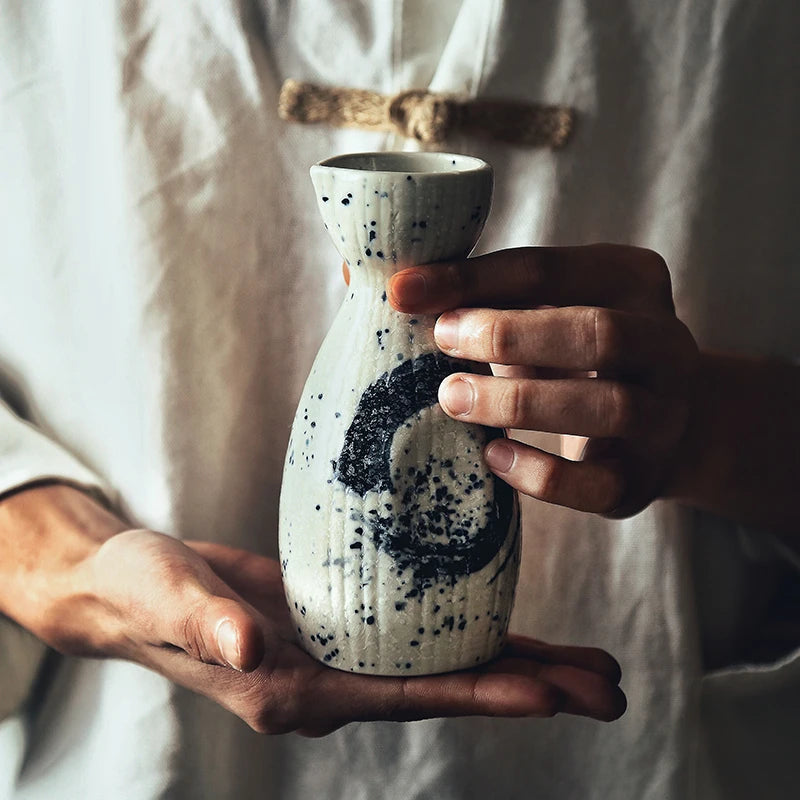 man holding the bottle of a authentic sake set